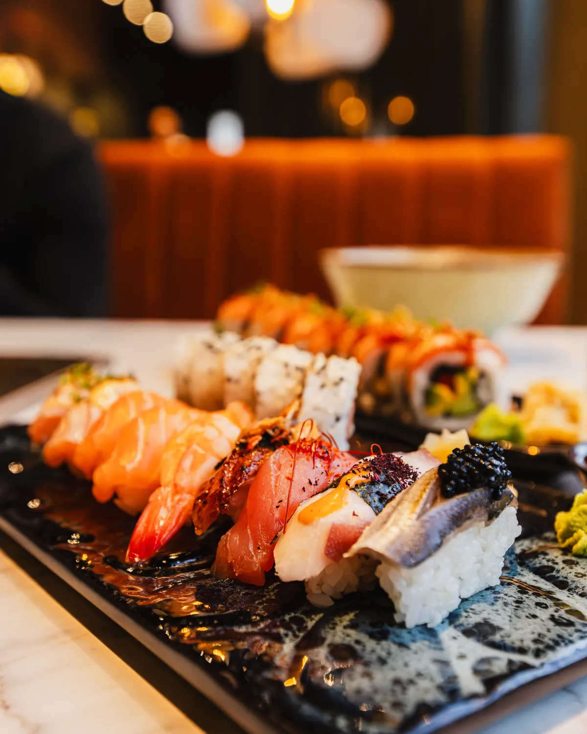 Nigiri och sushirullar upplagda på ett svart fat hos Tokyo Trio